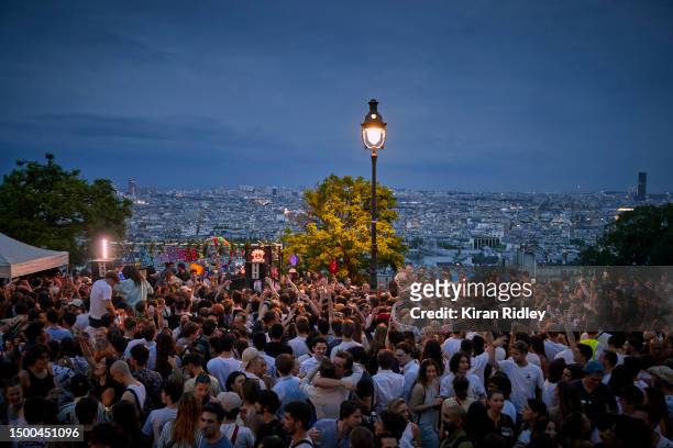 Parisians dance overlooking the city of Paris in a free dance set, part of Fête de la Musique, on the steps of Sacré-Coeur on June 21, 2023 in Paris,...