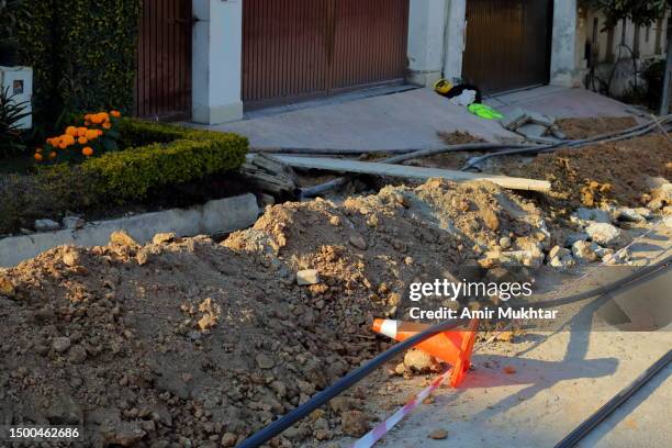 earth digs for laying internet cable underground in city street. - pipe replacement stock pictures, royalty-free photos & images