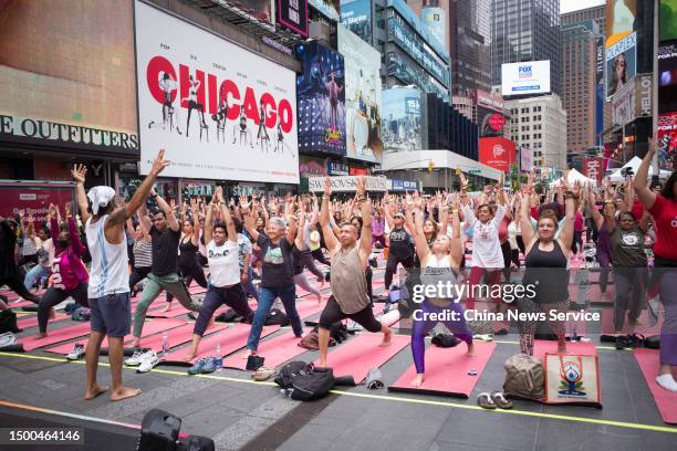 People practice yoga to welcome the International Day of Yoga at Times Square on June 21, 2023 in New York City.