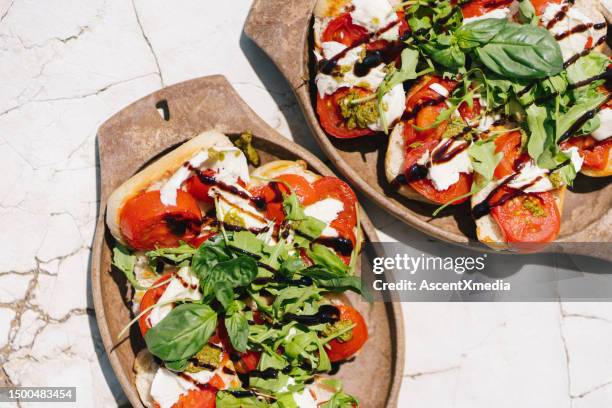 fresh caprese sandwich on a table - caprese stockfoto's en -beelden