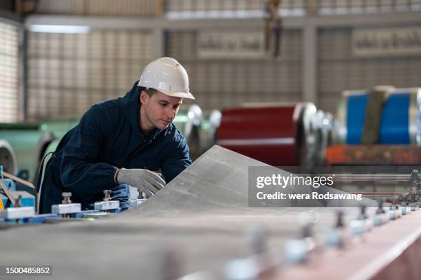 sheet metal fabrication design and manufacturing, production line worker inspecting sheet metal fabrication cutting on automation machine - hoja de aluminio fotografías e imágenes de stock
