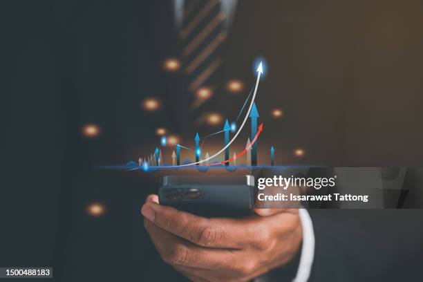 businessman with smartphone in hands analysing stock market changes, double exposure of city buildings, blue candlesticks. concept of online trading - man double exposure profit concept imagens e fotografias de stock