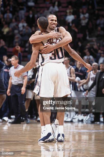 Two New Jersey Nets - forward Richard Jefferson and guard Kerry Kittles - celebrate during the NBA game at the Continental Airlines Arena in East...
