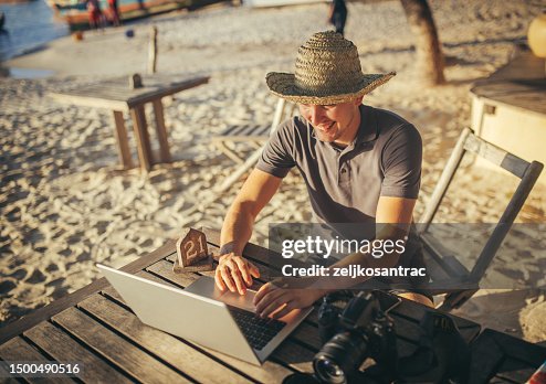 A freelance man works online in a cafe on the beach