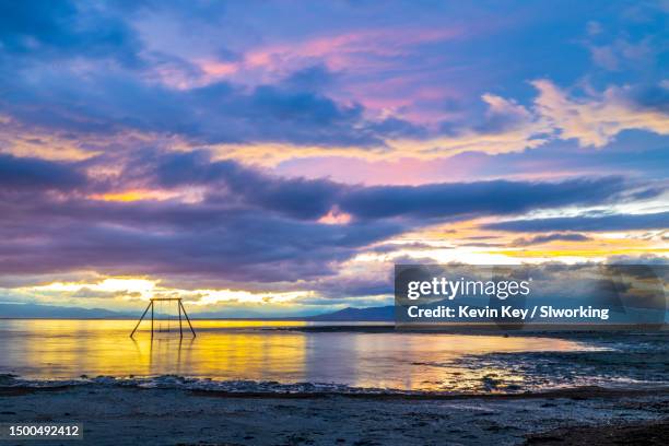 colorful sunset over swing set art installation at bombay beach - salton sea stock pictures, royalty-free photos & images