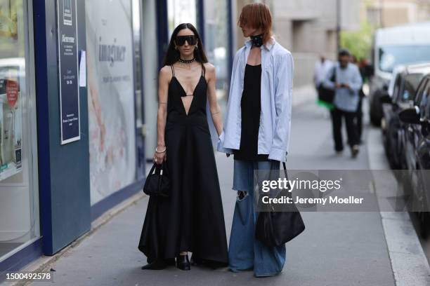 Ilenia Toma is seen wearing a black long dress, black statement shades, black mini bag and Simon Nygard is wearing a black leather metal rivets...