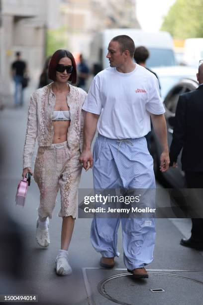 Alexandra Guerain is seen wearing a matching Acne Studios two piece with a beige jacket and beige capri pants, Miu Miu white bra, Acne Studios pink...