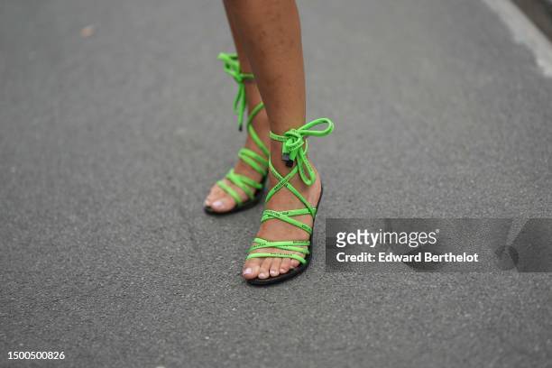 Guest wears neon green cordon strappy ankle sandals from Balenciaga, outside Bluemarble, during the Menswear Spring/Summer 2024 as part of Paris...