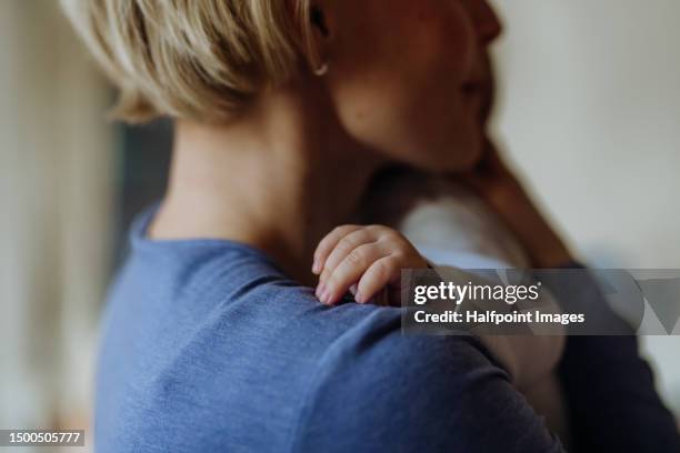 close up of mother holding and cuddling her baby. - baby hands stock pictures, royalty-free photos & images