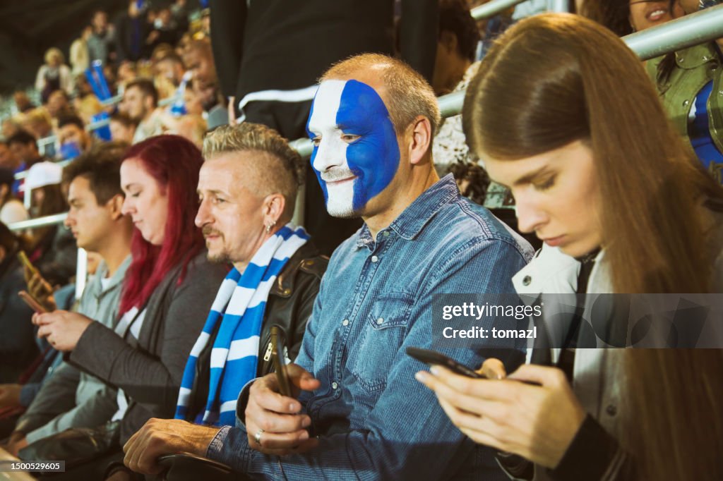 Soccer fan with face painted in club's colors