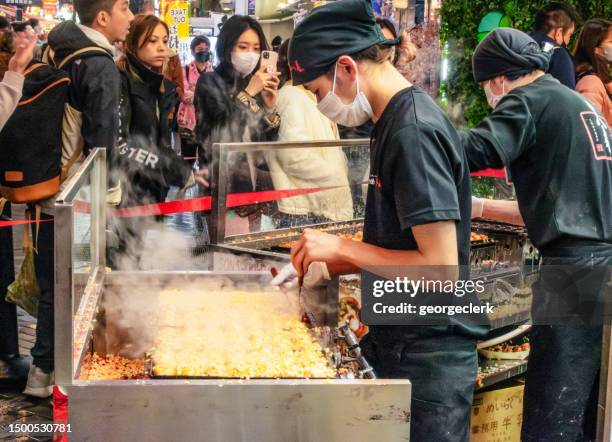 chefs preparing takoyaki street food in osaka - okonomiyaki 個照片及圖片檔