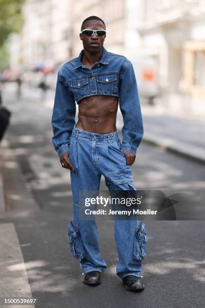 Fashion Week guest is seen wearing Bottega Veneta black and light blue shades, cropped jeans jacket and matching denim cargo pants outside EGONLAB...