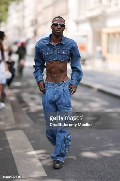 Fashion Week guest is seen wearing Bottega Veneta black and light blue shades, cropped jeans jacket and matching denim cargo pants outside EGONLAB...