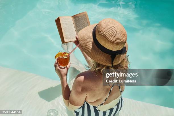 top view, woman and reading book by swimming pool with cocktail for holiday, vacation or summer break. person, novel or story by poolside with alcohol drink for self care, wellness and resort rest - ice tea stock pictures, royalty-free photos & images
