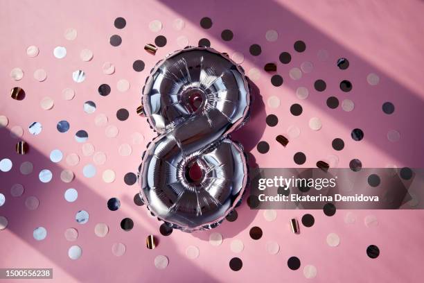 silver numbers 8 eight years balloons in sunlight pink background - 8 years stock-fotos und bilder