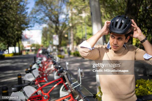 young man renting city bike - bicycle rental stock pictures, royalty-free photos & images