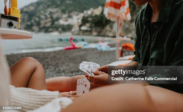 happy woman enjoy a game of cards on a beach. - id cards bildbanksfoton och bilder