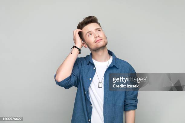thoughtful young man - man earring stock pictures, royalty-free photos & images
