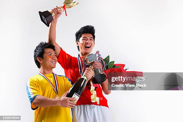 two young men holding trophy and champagne celebrating success - life after stroke awards 2011 stock pictures, royalty-free photos & images