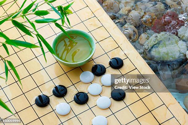 weiqi and bowl of green tea - chess board overhead stock pictures, royalty-free photos & images