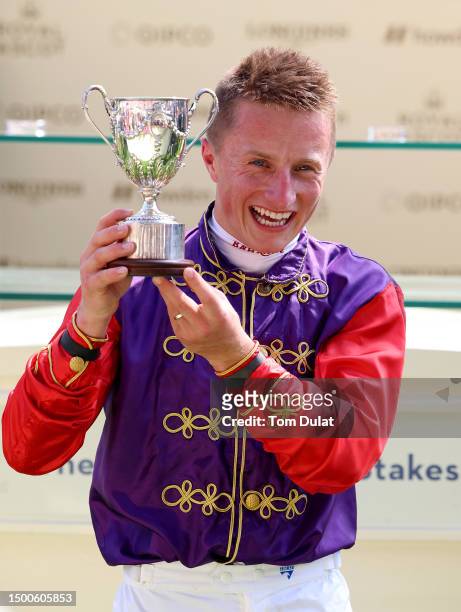 Tom Marquand riding Desert Hero poses with the trophy after winning The King George V Stakes on day three during Royal Ascot 2023 at Ascot Racecourse...