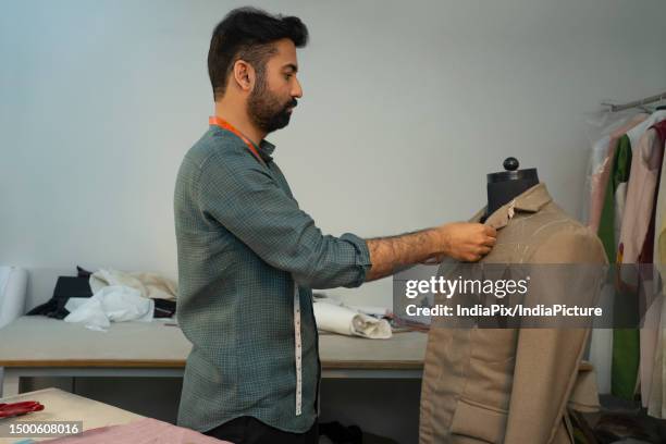 menswear designer working on a bespoke jacket in his studio - fashion designer stock pictures, royalty-free photos & images