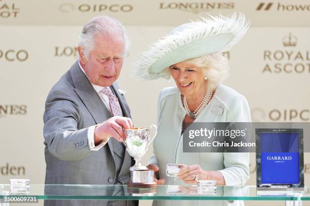 King Charles III and Queen Camilla are awarded the trophy for the King George V Stakes as owners of the horse Dessert Hero on day three of Royal...