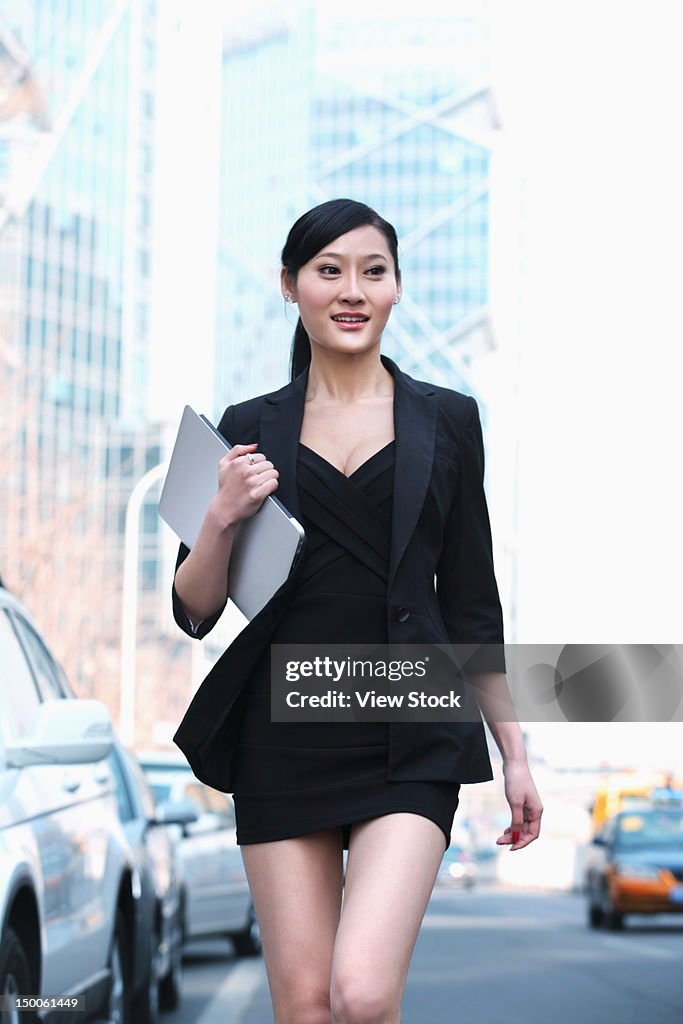 Businesswoman walking along street