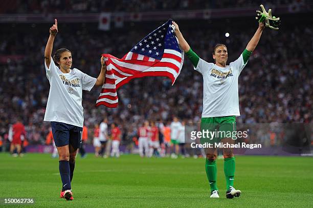 Hope Solo and Carli Lloyd of the United States celebrate with the American flag after defeating Japan by a score of 2-1 to win the Women's Football...