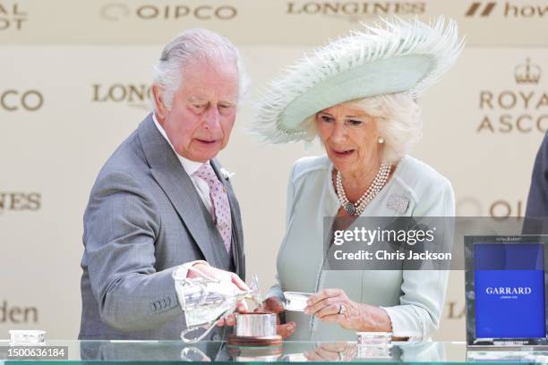 King Charles III is seen dropping the trophy for the King George V Stakes alongside Queen Camilla on day three of Royal Ascot 2023 at Ascot...