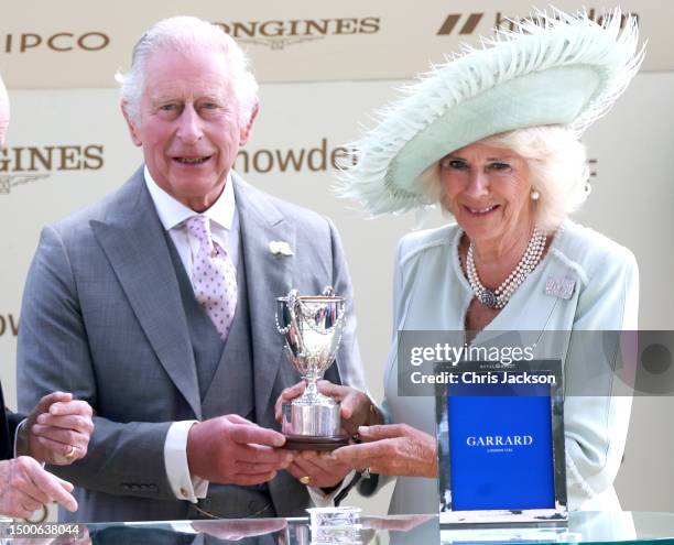 King Charles II and Queen Camilla holds the King George V Trophy after his horse horse Desert Hero won as they attend day three of Royal Ascot 2023...