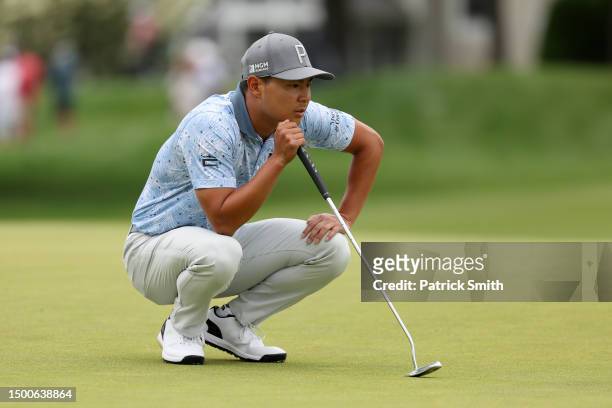 Justin Suh of the United States lines up a putt on the second green during the first round of the Travelers Championship at TPC River Highlands on...