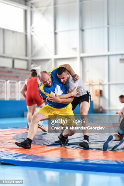 wrestler practicing head and arm throw on student - luta greco romana imagens e fotografias de stock