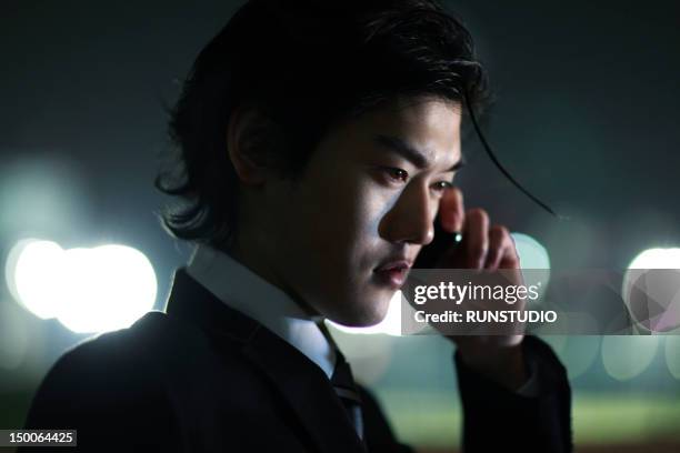 young businessman talking on mobile phone - night suit stock pictures, royalty-free photos & images