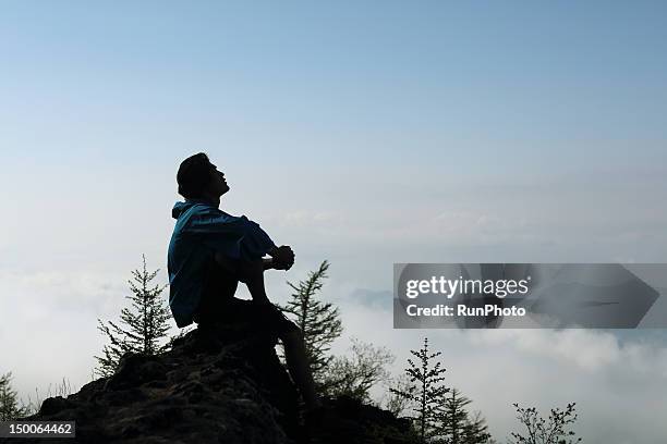 man resting in the mountain - silhouette sitting stock pictures, royalty-free photos & images