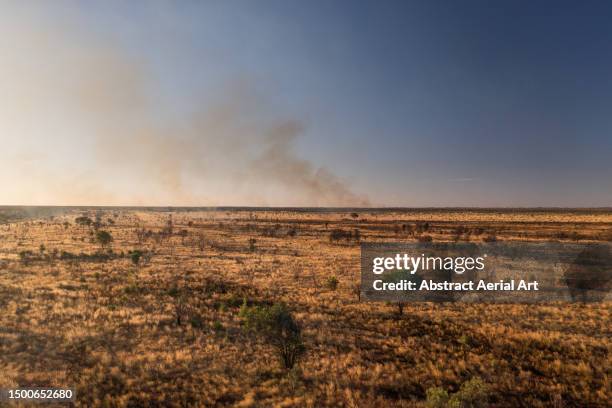 high angle shot showing smoke rising skywards from a distant wildfire, northern territory, australia - distant fire stock pictures, royalty-free photos & images