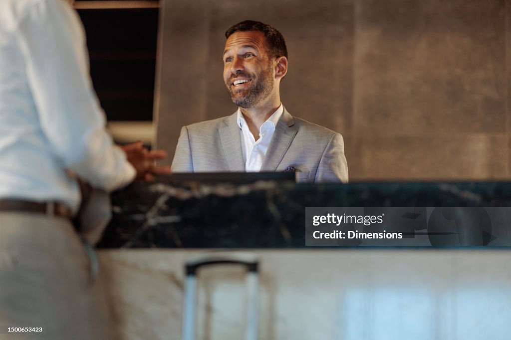 Client Hotel Content Happy Hotel Receptionist Having Conversation With Client High-Res Stock ...