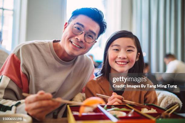 dad & daughter smiling joyfully at the camera while enjoying meal in a japanese restaurant - bento box stock pictures, royalty-free photos & images