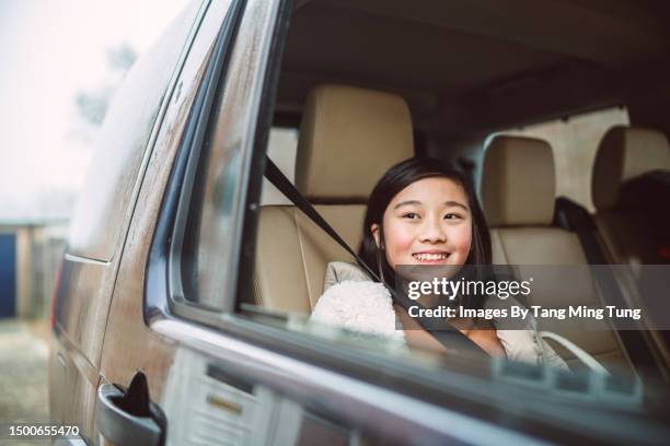 lovely girl sitting at the back seat of a car, looking outside car window while traveling - children in car stock pictures, royalty-free photos & images