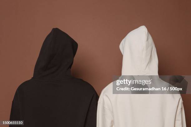 rear view of women wearing hijab standing against wall,indonesia - hooded top stock pictures, royalty-free photos & images