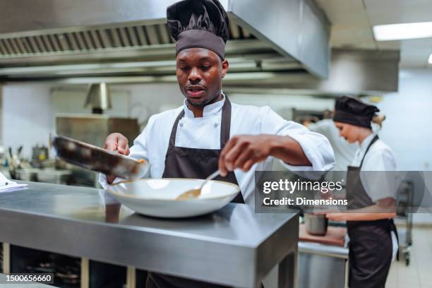 african-american chef finishing dish - catering stockfoto's en -beelden