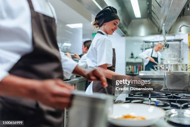equipo de cocina profesional trabajando en cocina - cocina comercial fotografías e imágenes de stock