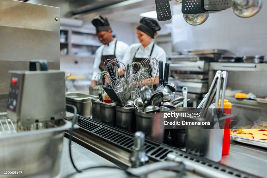 Close up image of kitchen elements and cooking team in background