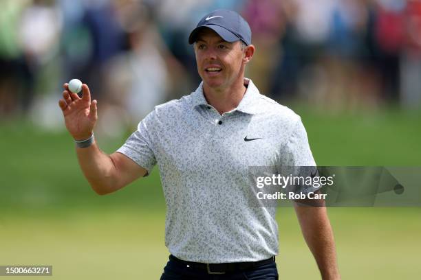 Rory McIlroy of Northern Ireland waves after making a hole-in-one on the eighth hole during the first round of the Travelers Championship at TPC...