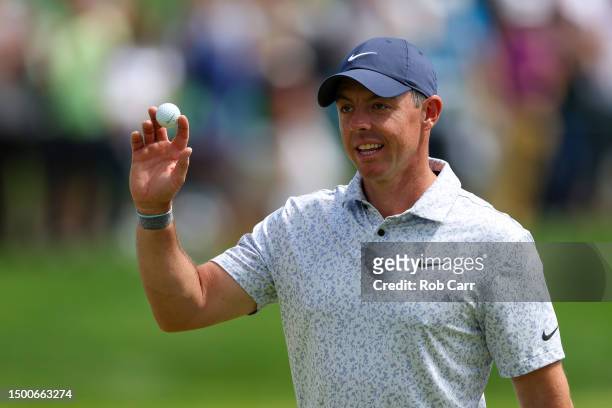 Rory McIlroy of Northern Ireland waves after making a hole-in-one on the eighth hole during the first round of the Travelers Championship at TPC...