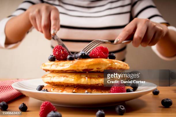 young woman eating pancakes in the morning - breakfast hotcakes - blueberry pancakes bildbanksfoton och bilder