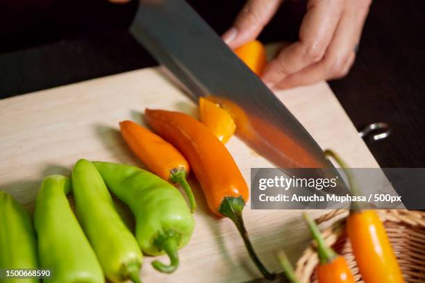 a hand chopped fresh chili peppers on a cutting board,bangkok,thailand - chilli pepper stock pictures, royalty-free photos & images