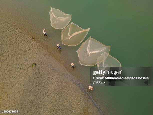 aerial view of fishermen with fishing net in lake,kaunia,bangladesh - bangladesh aerial stock pictures, royalty-free photos & images