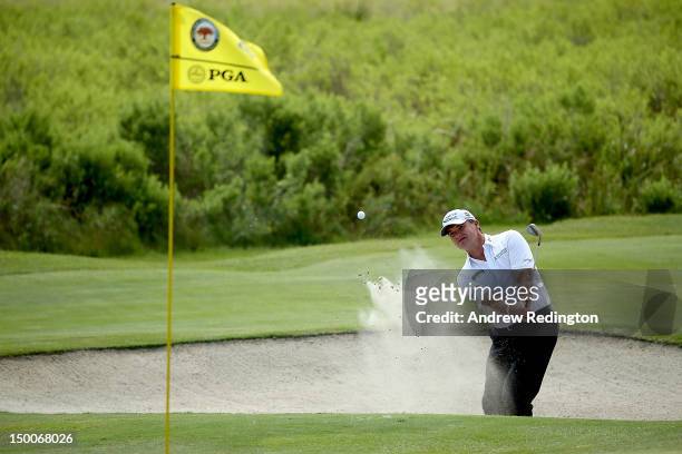 Paul Lawrie of Scotland hits out of the sand on the fourth hole during Round One of the 94th PGA Championship at the Ocean Course on August 9, 2012...