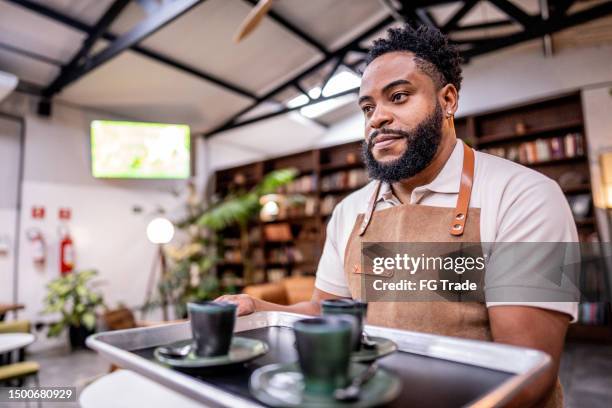 kellner trägt ein serviertablett mit kaffee in einem café - kantinenfrau stock-fotos und bilder